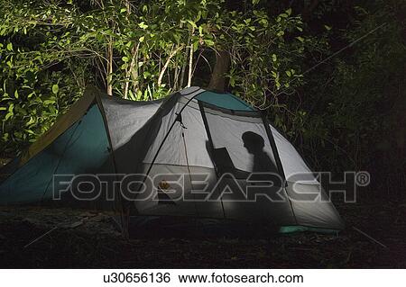 Stock Photograph - set, reading, lifestyle, environment, tent, person. Fotosearch