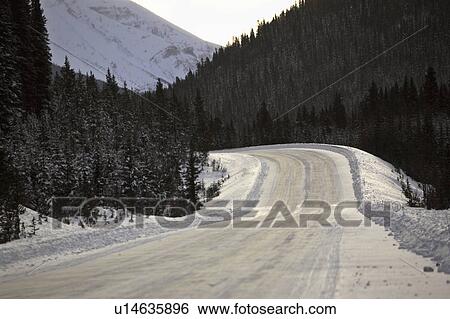 Stock Photograph - snow, mountains, highway, road, winter, rocky. Fotosearch
