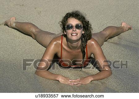 Stock Photo - stomach, bikini, sand, lying, model. Fotosearch