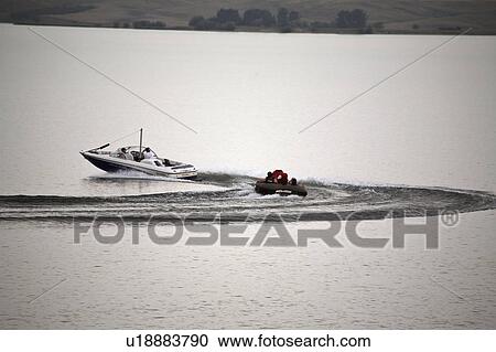 Stock Image - towing, diefenbaker, lake, raft, motorboat. Fotosearch