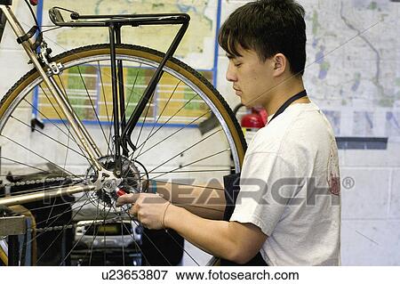 Stock Photo - wheel, american, bicycle, repairing, worker, asian. Fotosearch