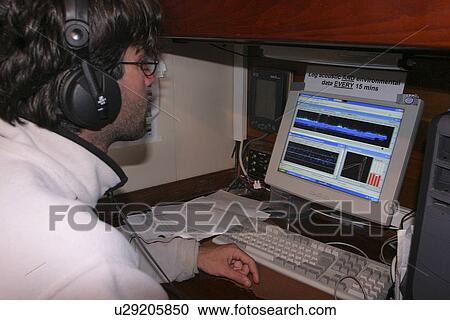 Stock Image - Dolphin biologist recording, and listening to dolphins vocalising around the research yacht Silurian. Hebrides, Scotland. (rr). Fotosearch