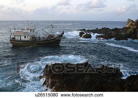 Stock Image - Fishing boat near bay, St. Peter and St. Paul's rocks, Brazil, Atlantic Ocean . Fotosearch