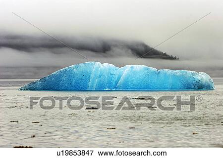 Stock Photo - Iceberg calved from Dawes or Sawyer Glaciers grounded on the terminal morraine in southeast Alaska, USA.. Fotosearch