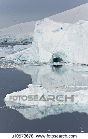 Stock Photo - Icebergs and brash ice reflected in calm waters on the west side of the Antarctic peninsula, Antarctica.. Fotosearch