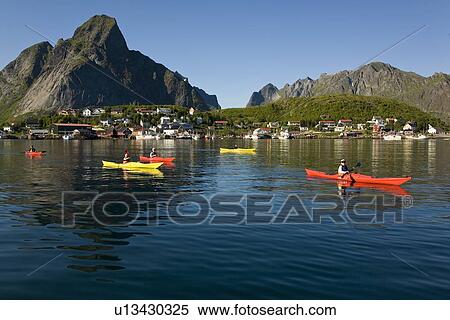 Kayakers in the late evening light on the picturesque Norwegian fishing town of Reine in the Lofoton Island Group, Norway. No model or property releases. View Large Photo Image Stock Photography - Kayakers in the late evening light on the picturesque Norwegian fishing town of Reine in the Lofoton Island Group, Norway. No model or property releases.. Fotosearch