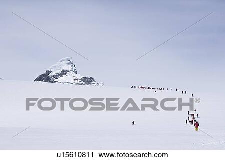 Stock Image - Lindblad Expeditions guests hiking on a glacier in Antarctica as part of expedition travel. NO MODEL RELEASES FOR THIS IMAGE.. Fotosearch