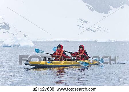 Stock Photo - Lindblad Expeditions guests kayaking in snowstorm in Antarctica as part of expedition travel. NO MODEL RELEASES FOR THIS IMAGE.. Fotosearch