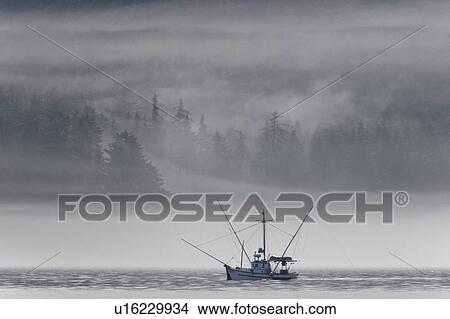 Picture - Low-lying clouds and fog create dramatic light on a fishing boat on the northern part of Kupreanof Island in Frederick Sound, Southeast Alaska, USA. Pacific Ocean.. Fotosearch