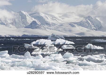 Stock Photo - Mist covers the glacier and icebergs and bergy bits in the bay in Neumayer Channel, Antarctica.. Fotosearch