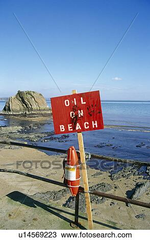 Stock Image - 'Oil on beach' sign. Tenby beach, Wales, UK. Fotosearch