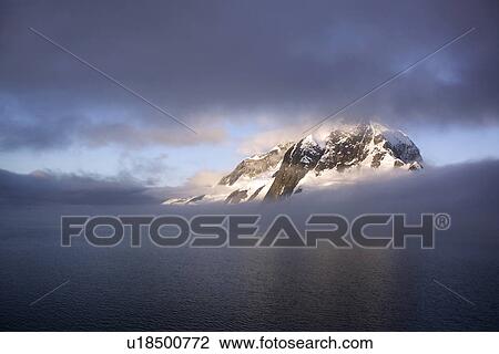 Shroud covered mountain peak in the magnificent Lemaire Channel, Antarctica. View Large Photo Image Stock Image - Shroud covered mountain peak in the magnificent Lemaire Channel, Antarctica.. Fotosearch