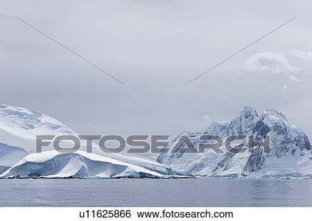 Snow-covered mountains near Petermann Island on the west side of the Antarctic Peninsula. View Large Photo Image Stock Photograph - Snow-covered mountains near Petermann Island on the west side of the Antarctic Peninsula.. Fotosearch