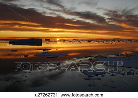 Stock Image - Sunset on fresh sea ice and tabular icebergs in the Weddell Sea, Antarctica.. Fotosearch
