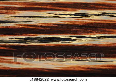 Stock Image - Sunset over the calm waters of the inside passage in Southeast Alaska, USA.. Fotosearch
