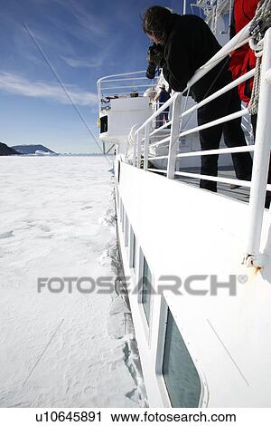Stock Image - The National Geographic Endeavour breaking through new fast ice around the Antarctic Peninsula. . Fotosearch