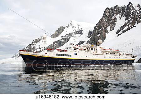 Stock Image - The National Geographic Endeavour pushing through brash ice and small icebergs in the Lemaire Channel near the Antarctic Peninsula.. Fotosearch