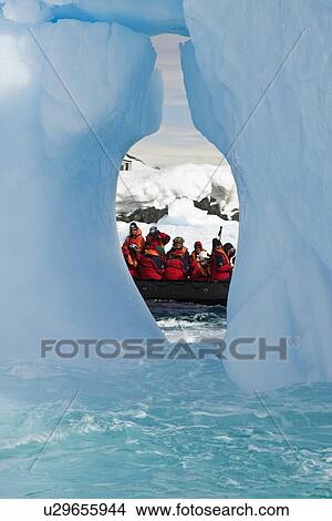 Picture - Zodiac and iceberg detail in and around the abandoned British research base "W" in Crystal Sound near the Antarctic Peninsula during the summer months. More icebergs are being created as global warming is causing the breakup of major ice shelves and glaci. Fotosearch