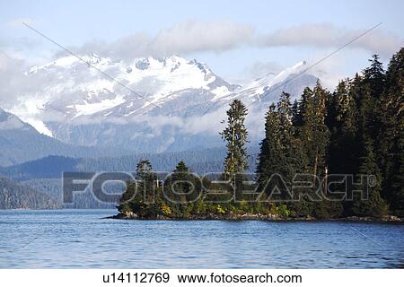 Stock Photo - A view of the cloud covered mountains just outside Petersburg in Southeast Alaska, USA.. Fotosearch