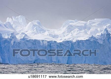Iceberg detail in and around Crystal Sound near the Antarctic Circle on the Antarctic Peninsula during the summer months. More icebergs are being created as global warming is causing the breakup of major ice shelves and glaciers. View Large Photo Image Stock Photo - Iceberg detail in and around Crystal Sound near the Antarctic Circle on the Antarctic Peninsula during the summer months. More icebergs are being created as global warming is causing the breakup of major ice shelves and glaciers.. Fotosearch
