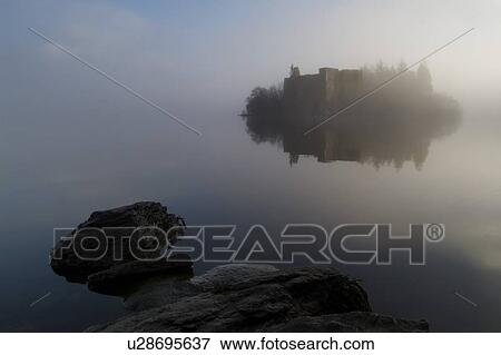 Stock Photo - Innischonnell castle on Loch, misty morning rocks in foreground, Argyll, Scotland. Argyll, Scotland. Fotosearch