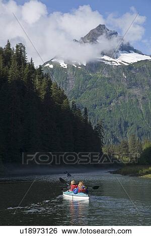 Stock Photograph - Kayaking in Red Bluff Bay on Baranof Island in Southeast Alaska, USA. Pacific Ocean. Kayak property release is DB051905. Model released numbers BM0807, JP0807, or DP0807.. Fotosearch