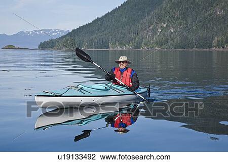 Stock Image - Kayaking in Windham Bay in Southeast Alaska, USA. Pacific Ocean. Kayak property release is DB051905. No model release.. Fotosearch