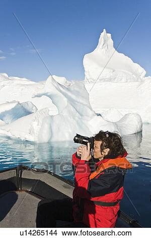 Lindblad Expeditions guest photographing icebergs from the Zodiac in Antarctica as part of expedition travel. NO MODEL RELEASES FOR THIS IMAGE. View Large Photo Image Picture - Lindblad Expeditions guest photographing icebergs from the Zodiac in Antarctica as part of expedition travel. NO MODEL RELEASES FOR THIS IMAGE.. Fotosearch