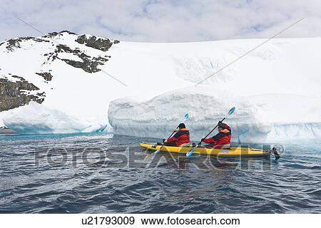 Stock Photo - Lindblad Expeditions guests kayaking beside icebergs in Antarctica as part of expedition travel. NO MODEL RELEASES FOR THIS IMAGE.. Fotosearch