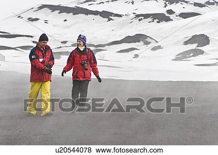 Lindblad Expeditions guests walking the volcanic beach inside the still active caldera on Deception Island in Antarctica as part of expedition travel. NO MODEL RELEASES FOR THIS IMAGE. View Large Photo Image Stock Photo - Lindblad Expeditions guests walking the volcanic beach inside the still active caldera on Deception Island in Antarctica as part of expedition travel. NO MODEL RELEASES FOR THIS IMAGE.. Fotosearch