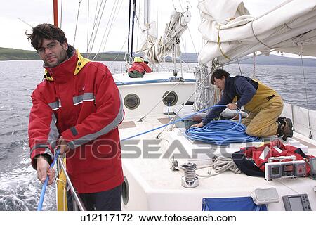 Stock Image - Scientists on research yacht, Silurian, paying out underwater hydrophone to record sounds made by cetaceans. Hebrides, Scotland. (rr). Fotosearch