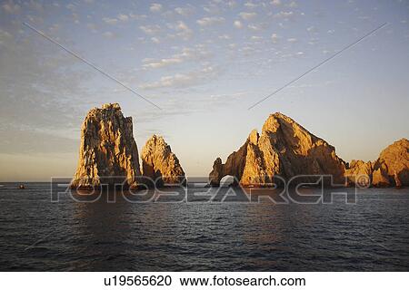 Stock Image - Sunrise on the famous finisterra (lands end) rock formation in Cabo San Lucas, Baja California Sur, Mexico.. Fotosearch