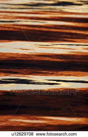 Stock Photo - Sunset over the calm waters of the inside passage in Southeast Alaska, USA.. Fotosearch