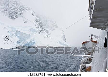 Stock Image - The National Geographic Endeavour transits the scenic Lemaire Channel in foggy conditions on the west side of the Antarctic peninsula in Antarctica.. Fotosearch