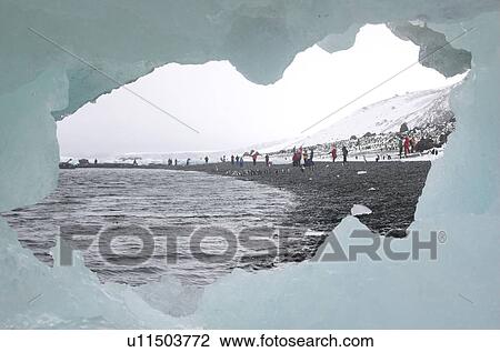 Stock Image - Tourists visiting the penguin colony of Brown Bluff, Antarctic Peninsula. Fotosearch