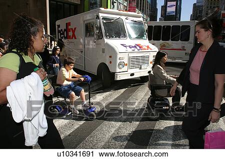 A woman and child with disabilities on a crossing a busy street in New York City. View Large Photo Image Stock Image - A woman and child with disabilities on a crossing a busy street in New York City.. Fotosearch