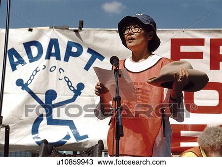 Stock Image - Asian-American woman speaking to a crowd of people with disabilities at the ADAPT March on Washington - an event to advocate for the civil rights of people with disabilities.. Fotosearch