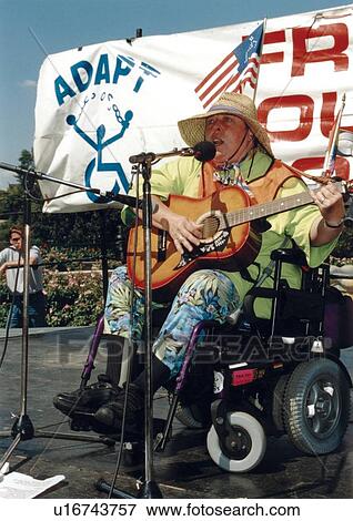 Gay Rights & Disability Rights Activist, utilizing a wheelchair for mobility, performing before a crowd of people. View Large Photo Image Stock Photo - Gay Rights & Disability Rights Activist, utilizing a wheelchair for mobility, performing before a crowd of people.. Fotosearch