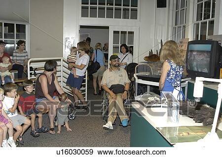Stock Photo - Group of people, including a man with disabilities, participating in an educational program.. Fotosearch