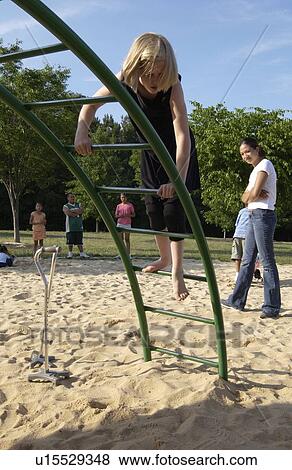 Stock Photo - Little girl with a disability leaving her cane behind to climb the jungle gym.. Fotosearch