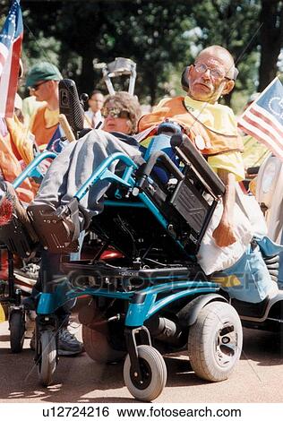 Stock Photograph - Man with multiple disabilities in a tilting power wheelchair participating in a national disability advocacy event.. Fotosearch