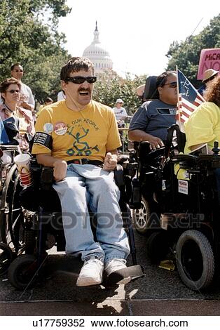 Stock Image - Man with multiple disabilities who utilizes a wheelchair for mobility participating in a national disability civil rights event, with the U. S. Capitol in the background.. Fotosearch