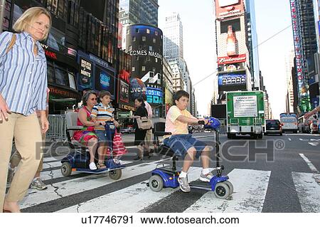 Son catching a ride on MomÆs scooter while crossing a street in New York City. View Large Photo Image Stock Image - Son catching a ride on MomÆs scooter while crossing a street in New York City.. Fotosearch