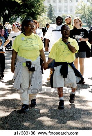 Stock Photo - Two friends walking hand-in-hand at an event.. Fotosearch