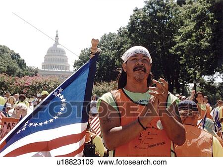 With the O. S. Capitol in the background, this man, with an ADAPT flag by his side, is listening to speakers at a national disability civil rights event. View Large Photo Image Stock Photo - With the O. S. Capitol in the background, this man, with an ADAPT flag by his side, is listening to speakers at a national disability civil rights event.. Fotosearch