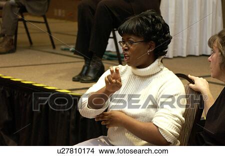 Woman interpreting for people with deafness and hearing impairments at a conference for people with disabilities. View Large Photo Image Picture - Woman interpreting for people with deafness and hearing impairments at a conference for people with disabilities.. Fotosearch