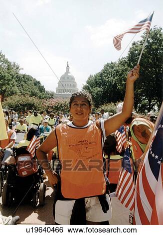 Woman waving flag, with the Nation's Capitol in the background, while attending the ADAPT March on Washington to advocate for the civil rights of people with disabilities. View Large Photo Image Stock Photograph - Woman waving flag, with the Nation's Capitol in the background, while attending the ADAPT March on Washington to advocate for the civil rights of people with disabilities.. Fotosearch