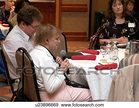Woman with a disability asking a question of a presenter at a disability rights conference. View Large Photo Image Stock Photo - Woman with a disability asking a question of a presenter at a disability rights conference.. Fotosearch