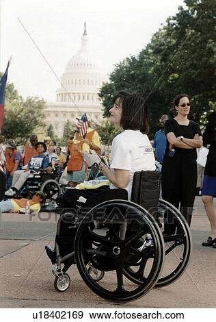 Woman with a disability who utilizes a wheelchair for mobility listens to a speaker with other people with disabilities at the ADAPT March on Washington Disability Advocacy event. View Large Photo Image Stock Photo - Woman with a disability who utilizes a wheelchair for mobility listens to a speaker with other people with disabilities at the ADAPT March on Washington Disability Advocacy event.. Fotosearch