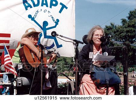 Woman with a disability, with a guitar player in the background, speaking to a crowd of people with disabilities at the ADAPT March on Washington Freedom Rally. View Large Photo Image Stock Photography - Woman with a disability, with a guitar player in the background, speaking to a crowd of people with disabilities at the ADAPT March on Washington Freedom Rally.. Fotosearch